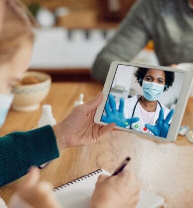 A family consulting a Live Video Virtual Medical Assistant via a tablet during an online healthcare appointment.