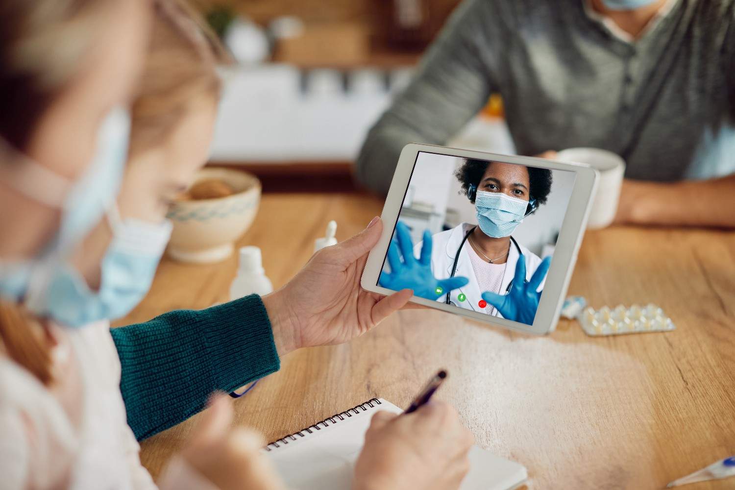 A family consulting a Live Video Virtual Medical Assistant via a tablet during an online healthcare appointment.