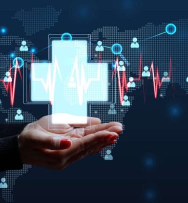 Global healthcare outsourcing concept with a hand holding a digital medical cross, representing healthcare solutions by Staffingly.