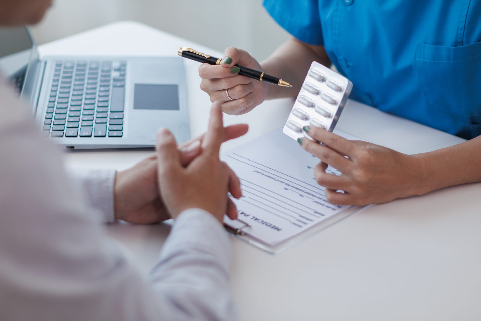 A healthcare professional reviewing a patient’s medical file and prior authorization forms for dosage adjustments.