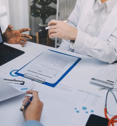 A healthcare provider reviewing prior authorization documents on a computer screen.