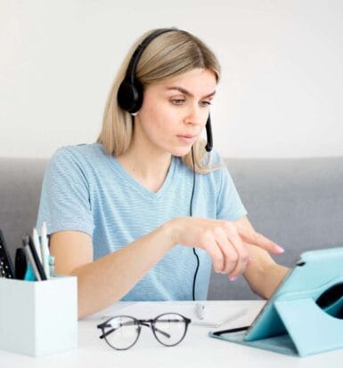 A virtual medical assistant wearing a headset, working on a tablet while managing healthcare tasks remotely.