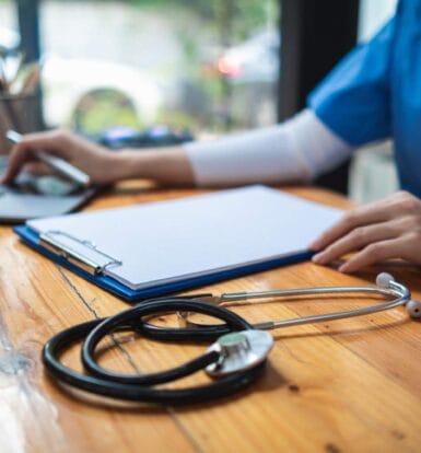 A healthcare professional verifying insurance details on a computer screen.