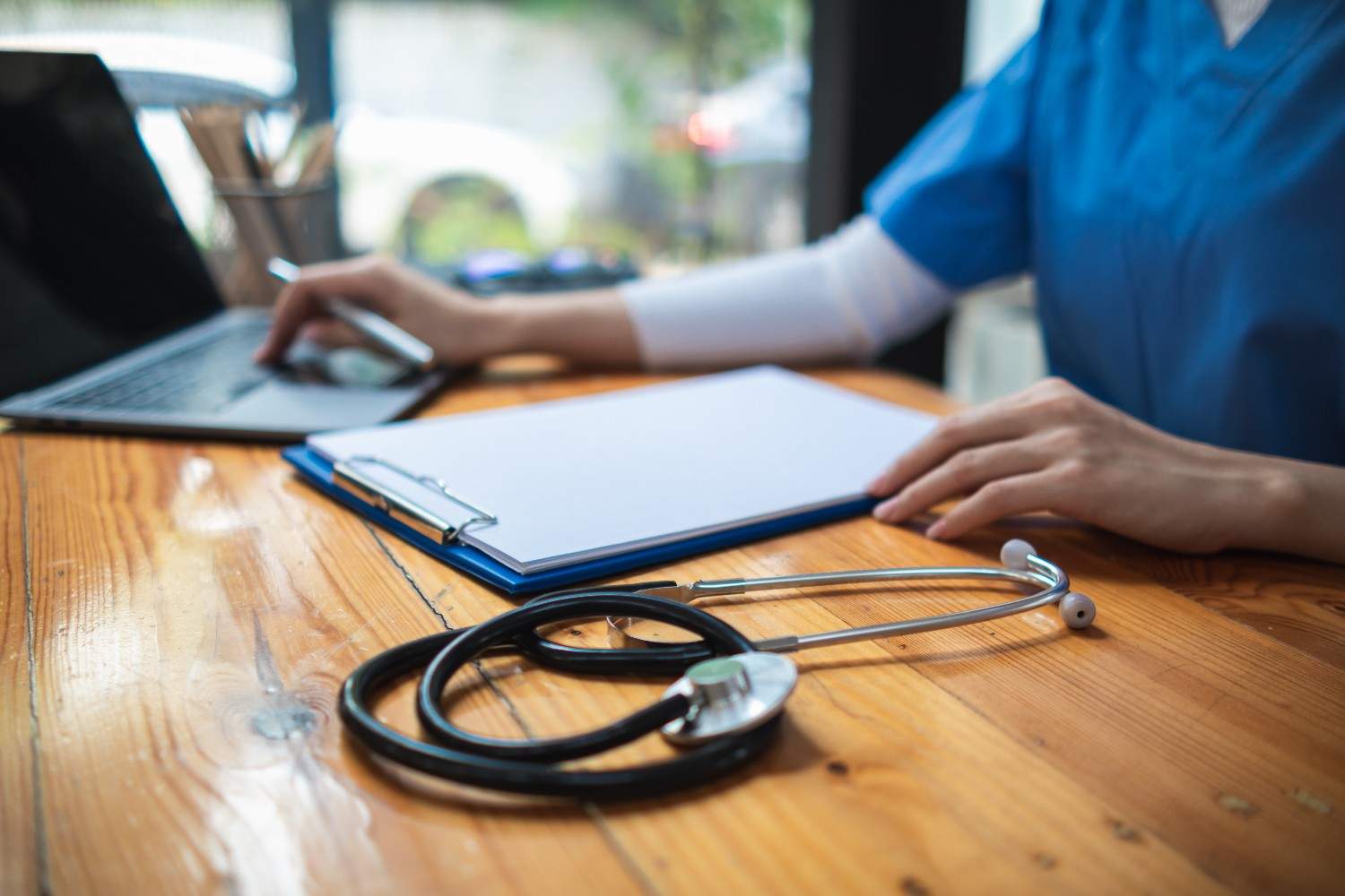 A healthcare professional verifying insurance details on a computer screen.