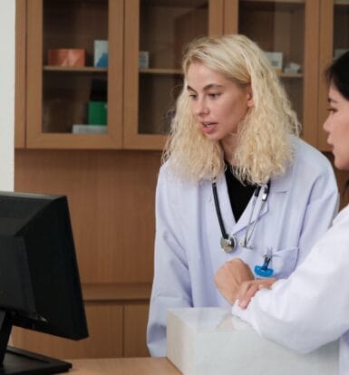 Pharmacy staff working on insurance claims with virtual support from an outsourcing partner.