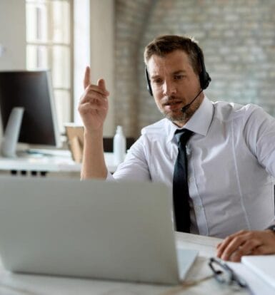 A professional virtual medical assistant wearing a headset and working remotely on a laptop to support healthcare operations.