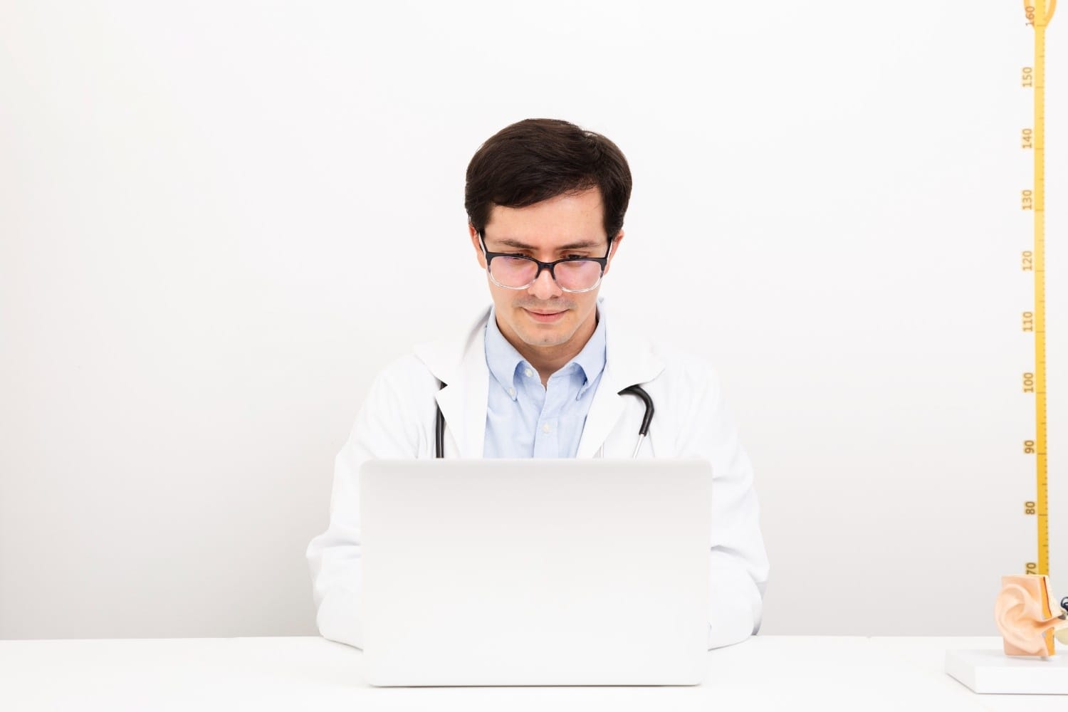 Doctor working on a laptop to manage Revenue Cycle Management tasks efficiently, representing virtual medical outsourcing in RCM.