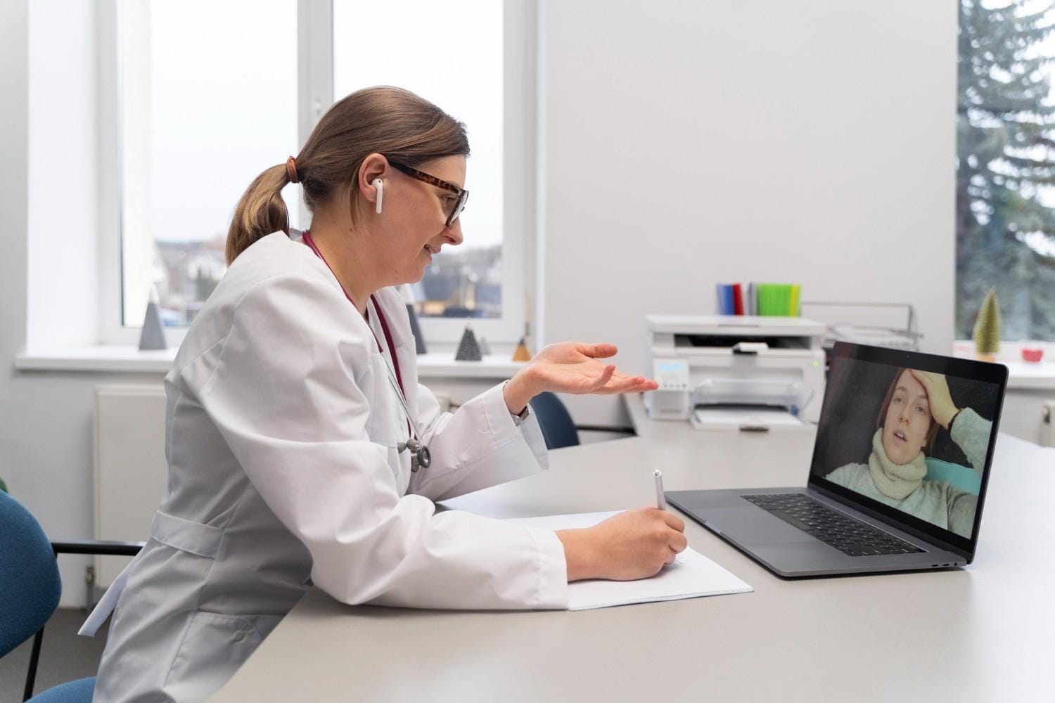 Doctor conducting a telemedicine consultation with a patient over a laptop, demonstrating virtual medical outsourcing support.