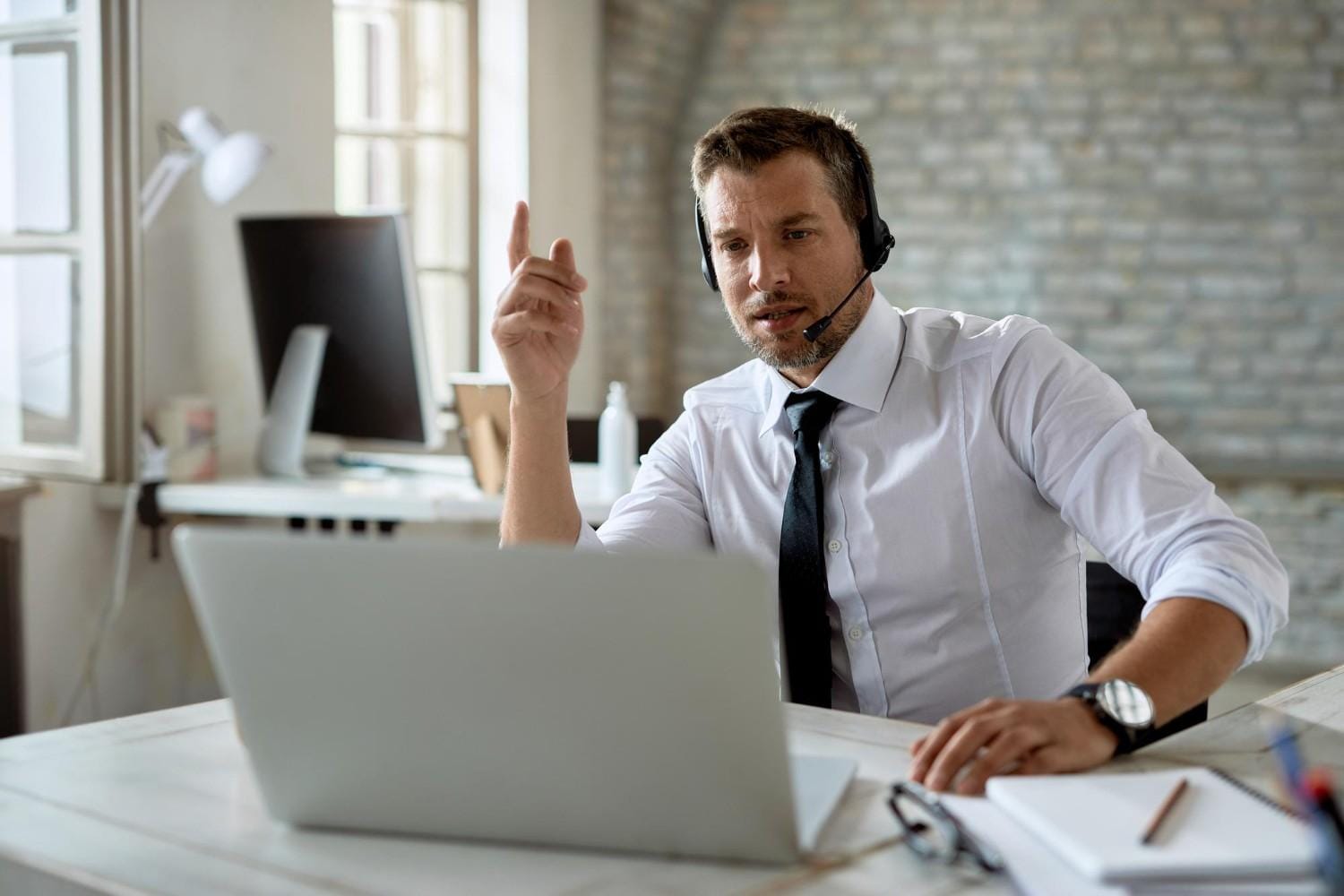 A professional virtual medical assistant wearing a headset and working remotely on a laptop to support healthcare operations.