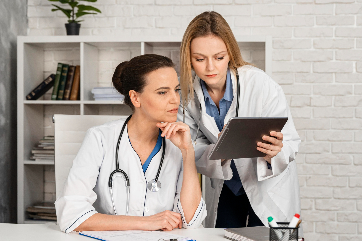 A medical scribe assisting a doctor with EHR documentation in a Rhode Island healthcare facility.