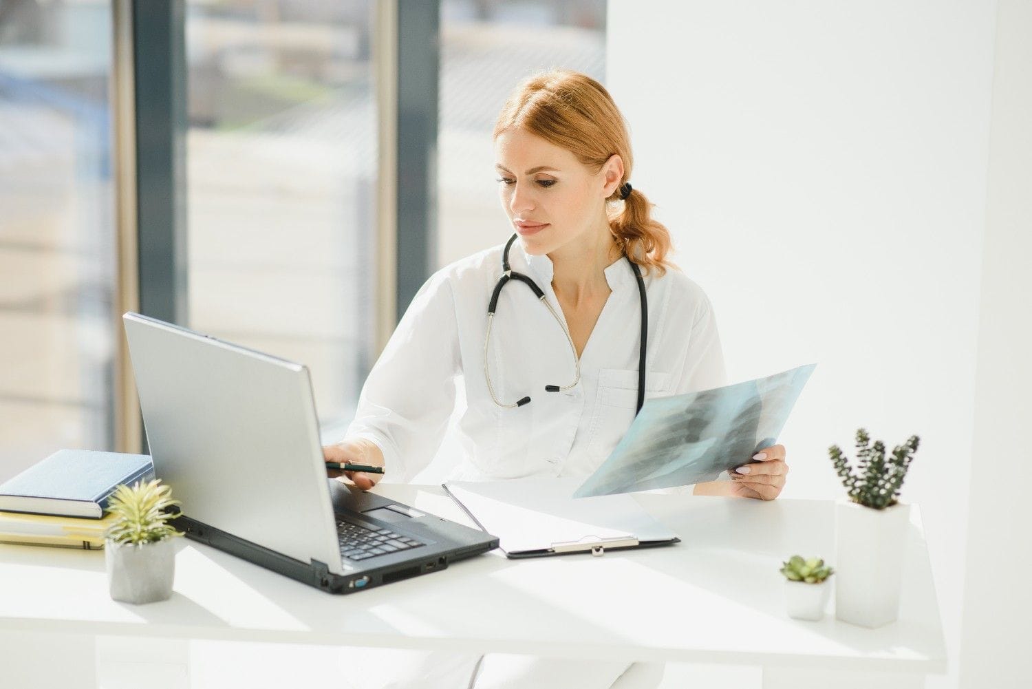 Medical coder reviewing patient charts on a computer in a Florida clinic.