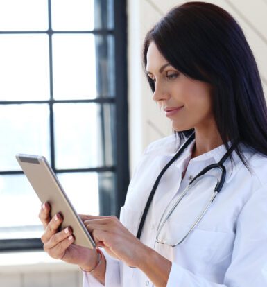 A determined female doctor meticulously reviews and enters medical data into a computer, ensuring accuracy and efficiency in patient care.