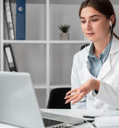 Healthcare professional using a laptop with earphones, showcasing virtual assistant services for medical billing and administration.