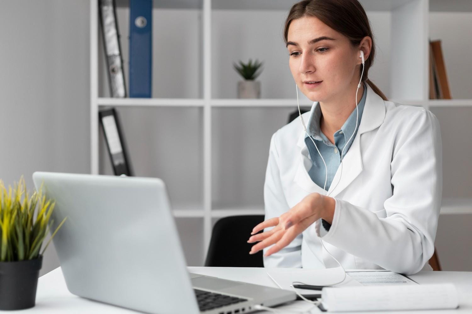 Healthcare professional using a laptop with earphones, showcasing virtual assistant services for medical billing and administration.