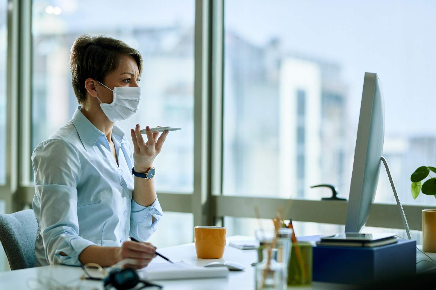 Medical Virtual Assistant in NYC wearing a mask, managing healthcare tasks remotely, focusing on administrative efficiency.