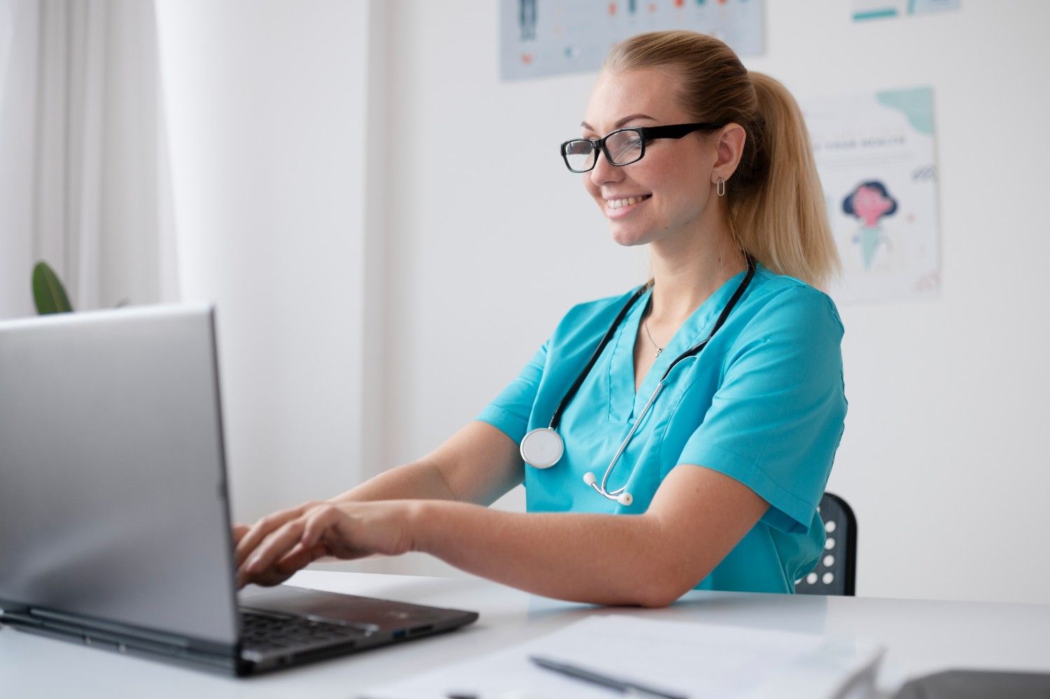 Smiling virtual medical assistant in scrubs using a laptop to provide administrative support for healthcare providers in New Jersey.