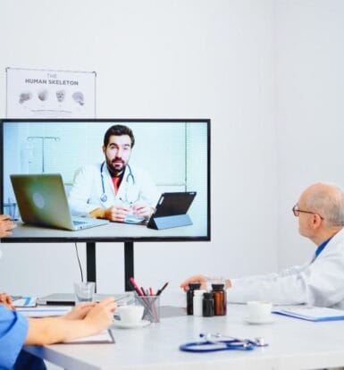 Healthcare professionals attending a virtual consultation with a doctor, showcasing the effectiveness of telemedicine coordination.