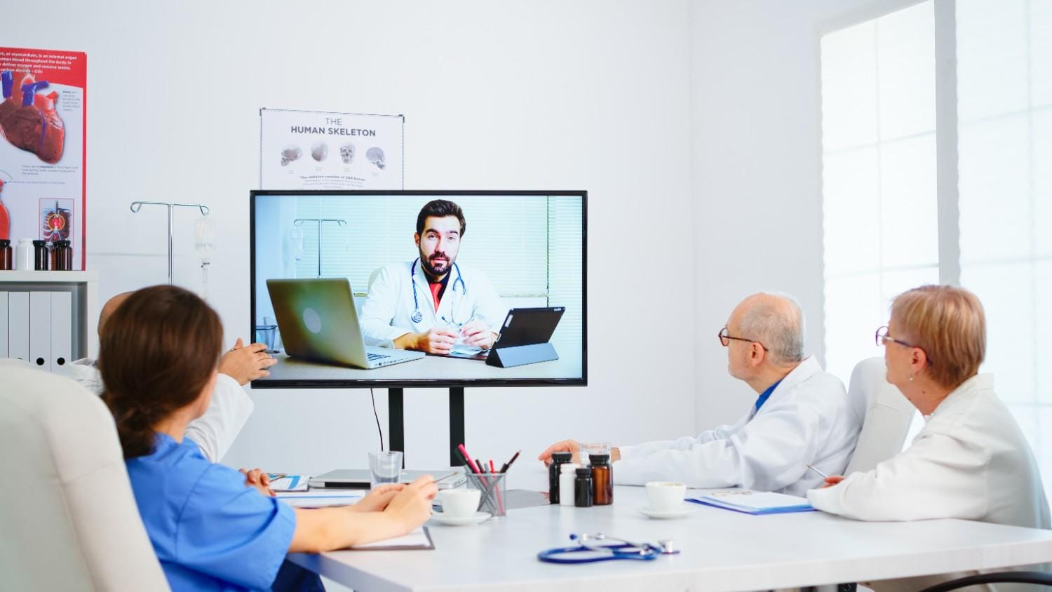 Healthcare professionals attending a virtual consultation with a doctor, showcasing the effectiveness of telemedicine coordination.