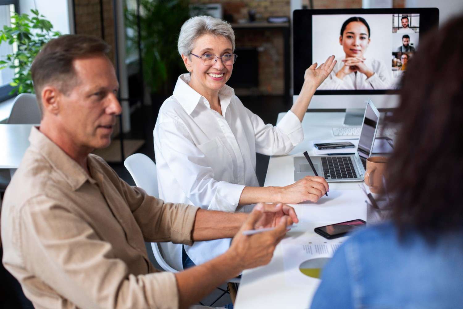 Healthcare professionals collaborating with virtual teams during a remote meeting, showcasing efficiency and teamwork in healthcare.