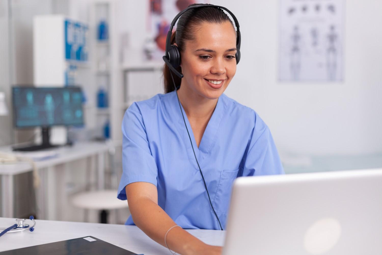 "Virtual receptionist supporting healthcare practice with headset and laptop"