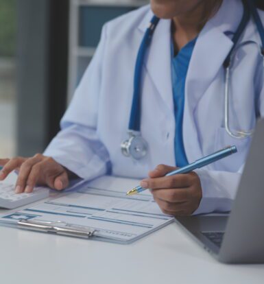 Medical coder working on a computer with CPT and ICD-10 codes displayed.