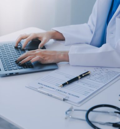 A healthcare professional reviewing digital patient records with a focus on HIPAA compliance in medical coding.