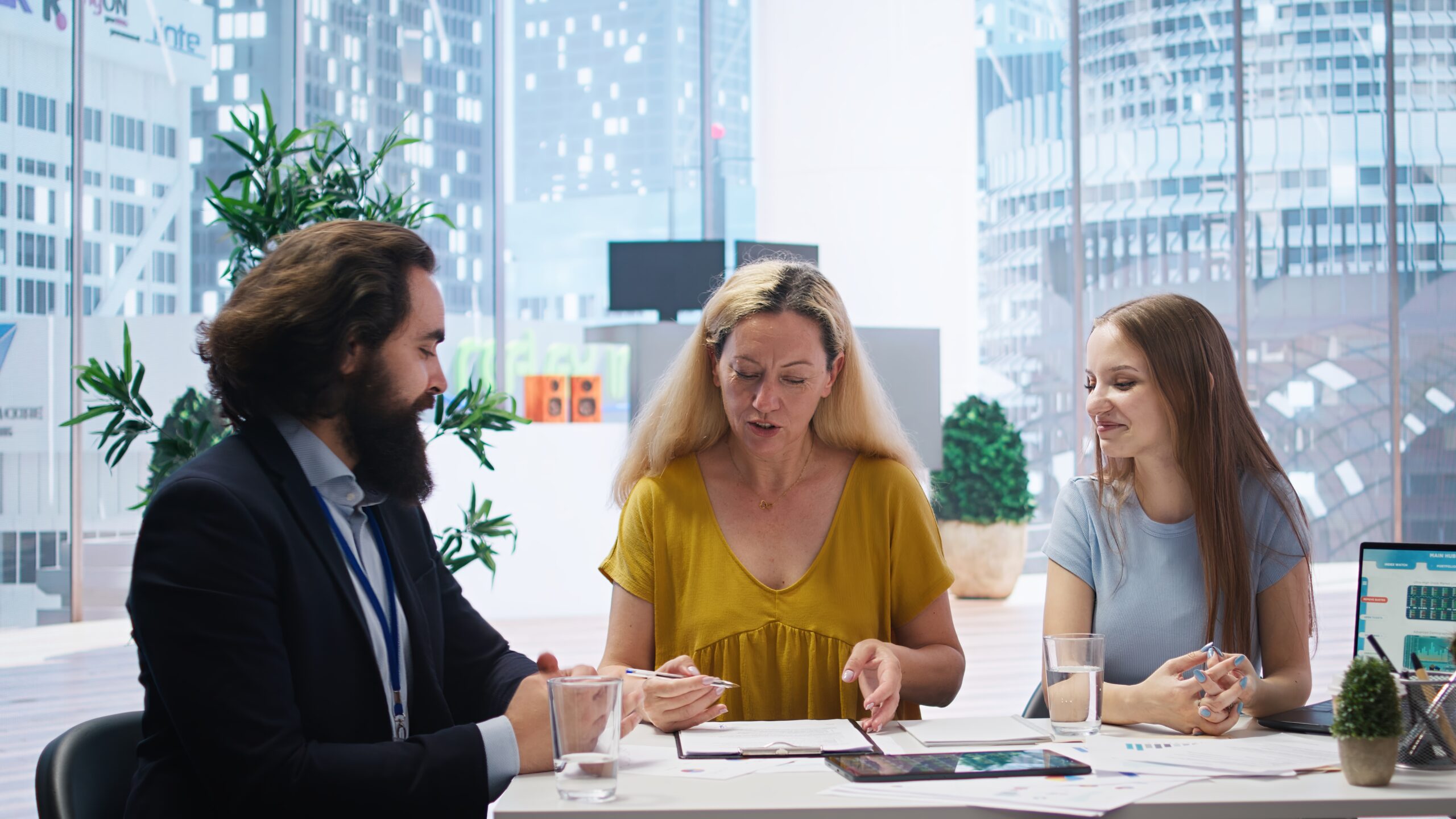 A healthcare team of three professionals collaborating on strategies to improve prior authorization processes in a modern office setting.