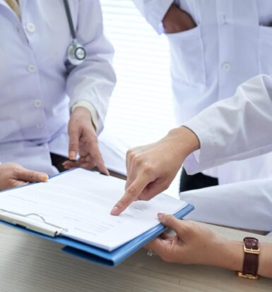 Doctors reviewing prior authorization documents in a hospital setting - Prior Authorization Outsourcing for Hospitals