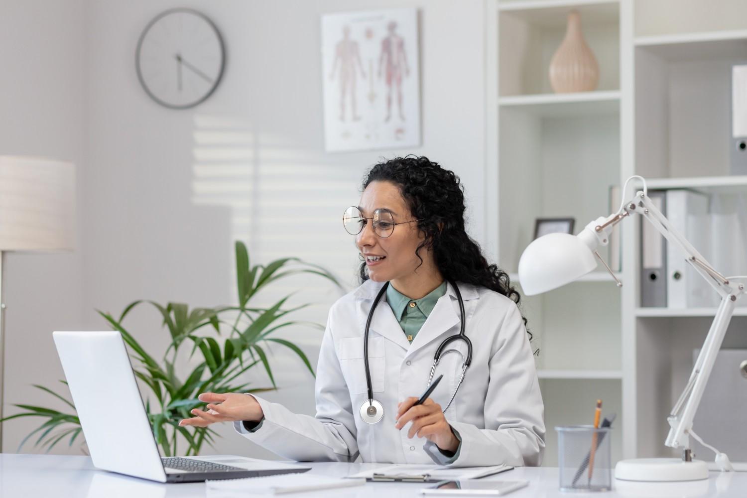 Female doctor using a laptop for a virtual consultation, representing the benefits of a Virtual Medical Assistant for Work-Life Balance.